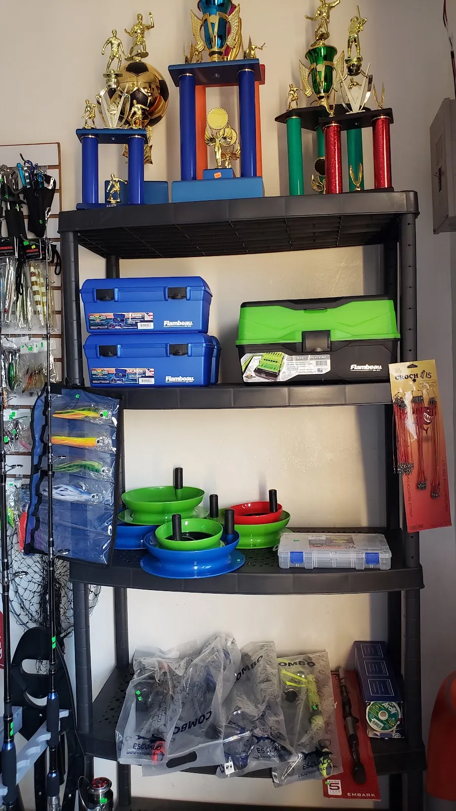 Estante con cajas de pesca y trofeos en la tienda de Rivas